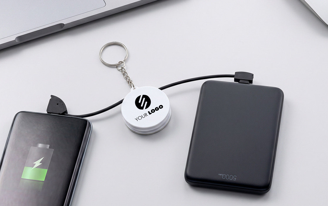 Multifunctional keychain charging cable for on-the-go use Multiple electronic devices connected and charged via a round, customizable USB cable with keychain.