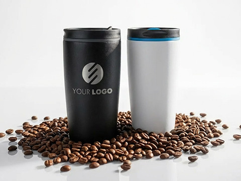 myMetz Thermobecher mit individueller Veredelung Zwei myMetz Thermobecher, einer schwarz mit Logo, einer weiß mit blauem Ring, stehend auf Kaffeebohnen