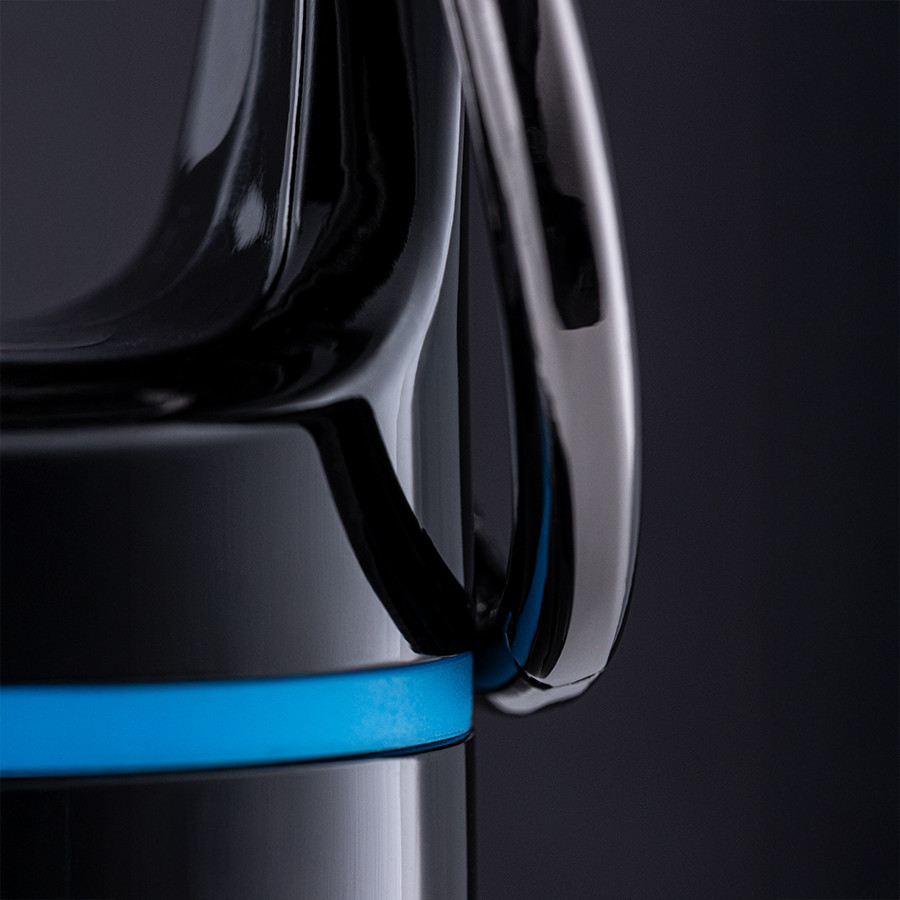 Close‑up van een zwarte retumbler‑flesdop met blauwe siliconen ring en metalen lus