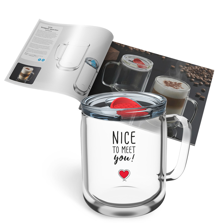NIZZA doppelwandiges Glas mit Herzmotiv und Katalog Doppelwandiger Glasbecher mit Henkel und dem Aufdruck „NICE TO MEET you!“ mit rotem Herz, dahinter ein aufgeklappter Produktkatalog mit weiteren NIZZA Glas‑Motiven auf weißem Hintergrund.