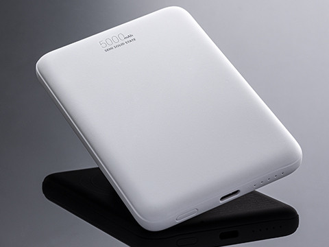 White power bank for mobile charging with slim design and capacity marking on a dark background.