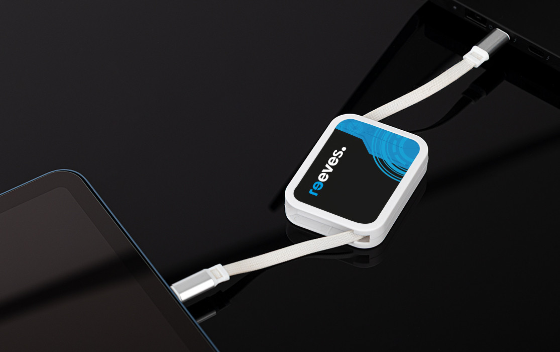 REEVES-WATTULA charging cable in white and blue, connected to a tablet on a black surface